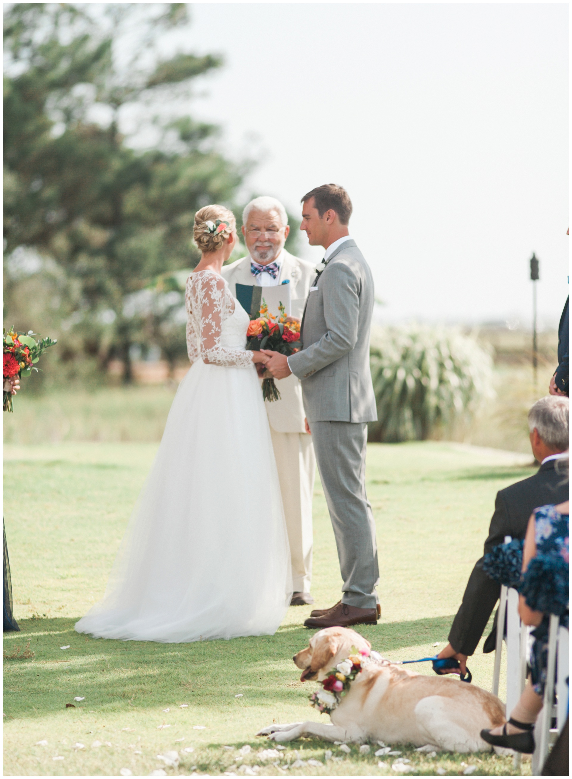 Bride and groom exchange vows on the lawn at their Regatta Inn Wedding